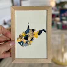 Load image into Gallery viewer, Gold metal framed cutout of West Virginia with gold leaf and yellow, medium blue, and navy paint chips from artist Emily Kurth's palette.
