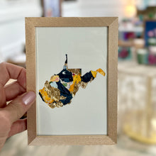 Load image into Gallery viewer, Gold metal framed cutout of West Virginia with gold leaf and yellow, and navy paint chips from artist Emily Kurth's palette.