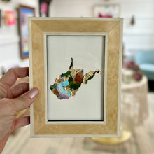 Load image into Gallery viewer, Blonde lacquered wood framed cutout of West Virginia with gold leaf and green, teal, light pink and brown paint chips from artist Emily Kurth's palette.