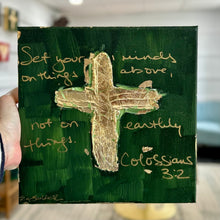 Load image into Gallery viewer, Painting of a textured gold leaf cross on a dark green background by artist Emily Kurth.  Scripture written on background, Set your minds on things above, not on earthly things. Colossians 3:2