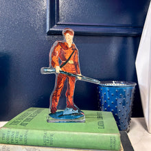 Load image into Gallery viewer, Acrylic cutout of the West Virginia University mascot, the Mountaineer holding his musket against a blue background.  Original artwork by artist Emily Kurth.