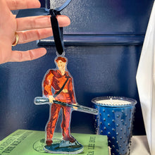 Load image into Gallery viewer, Acrylic ornament of the West Virginia University mascot, the Mountaineer holding his musket against a blue background.  Original artwork by artist Emily Kurth.