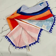 Load image into Gallery viewer, Decorative tea towel with blueberries on light and dark orange striped background design on marled surface.