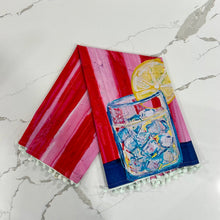 Load image into Gallery viewer, Decorative tea towel with lemonade design on red and pink striped background on marble surface.