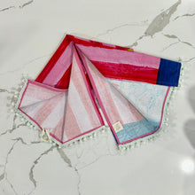 Load image into Gallery viewer, Decorative tea towel with lemonade design on red and pink striped background on marble surface.