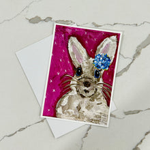 Load image into Gallery viewer, Card with a rabbit illustration wearing a blue bow on a pink background, placed on a marble surface.