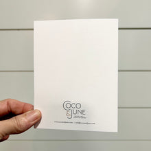 Load image into Gallery viewer, Hand holding a white card with 'Coco &amp; June' branding against a light gray background