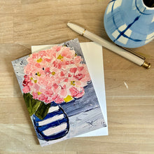 Load image into Gallery viewer, Greeting card with pink hydrangea floral design on a wooden surface with a pen and a vase.