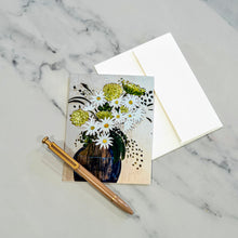 Load image into Gallery viewer, Greeting card with daisy and hydrangea floral design on a marble surface with a pen.